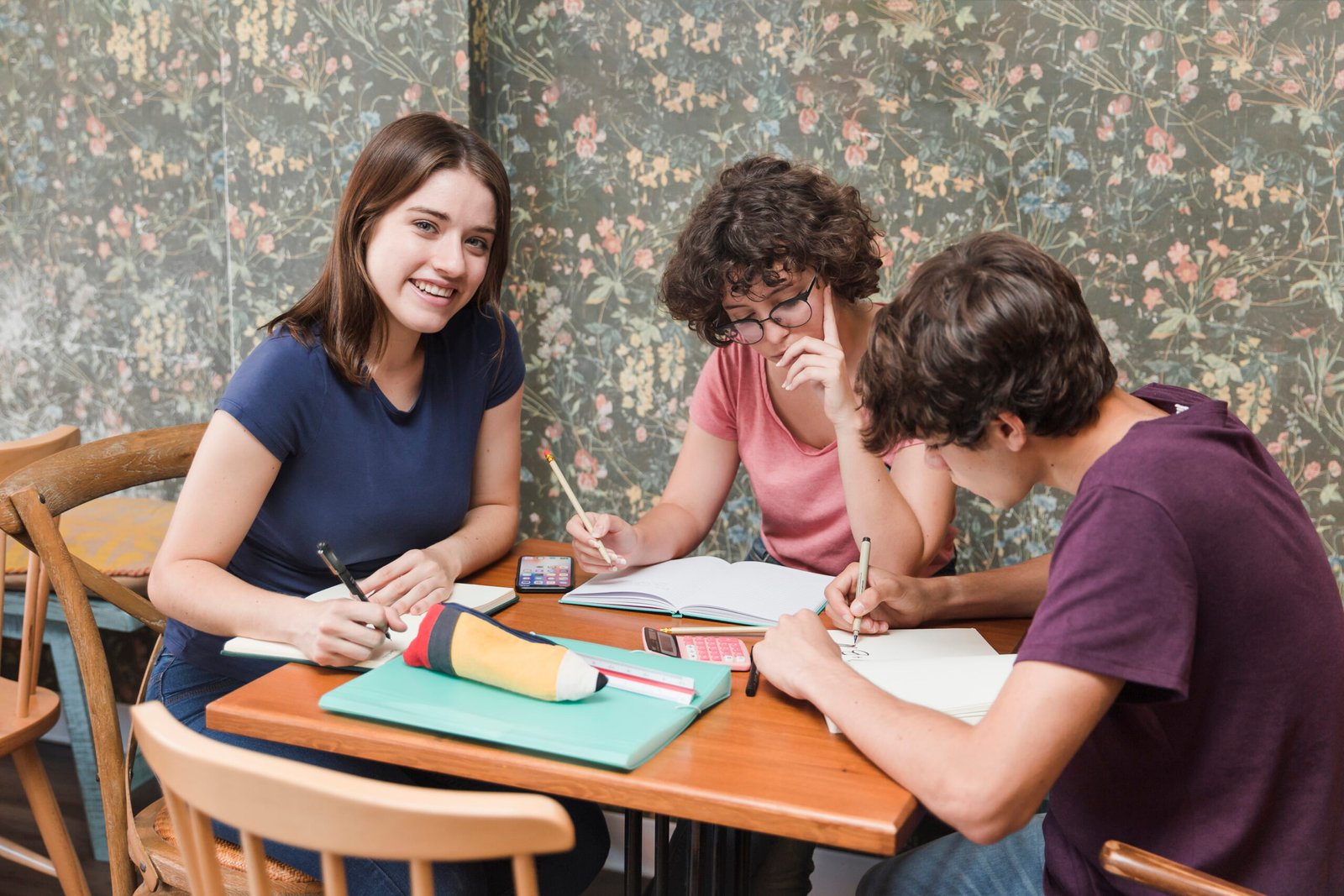 teen girl doing homework with friends